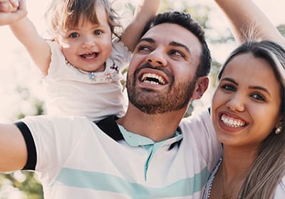 smiling family with man holding child above him