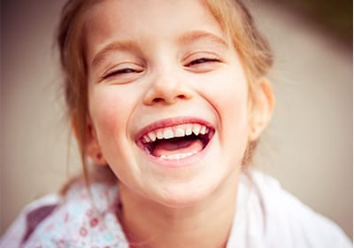 child sitting on the ground and laughing