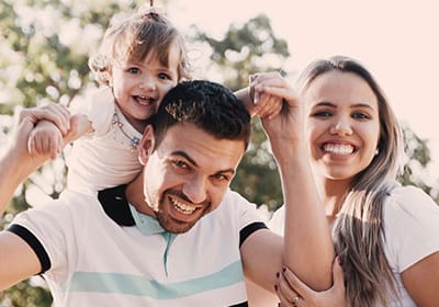 happy family with dad holding child on his shoulders