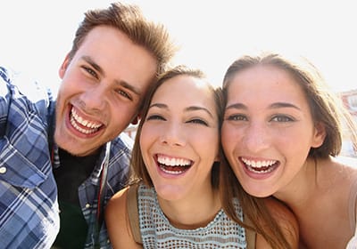 three friends taking a selfie and smiling big